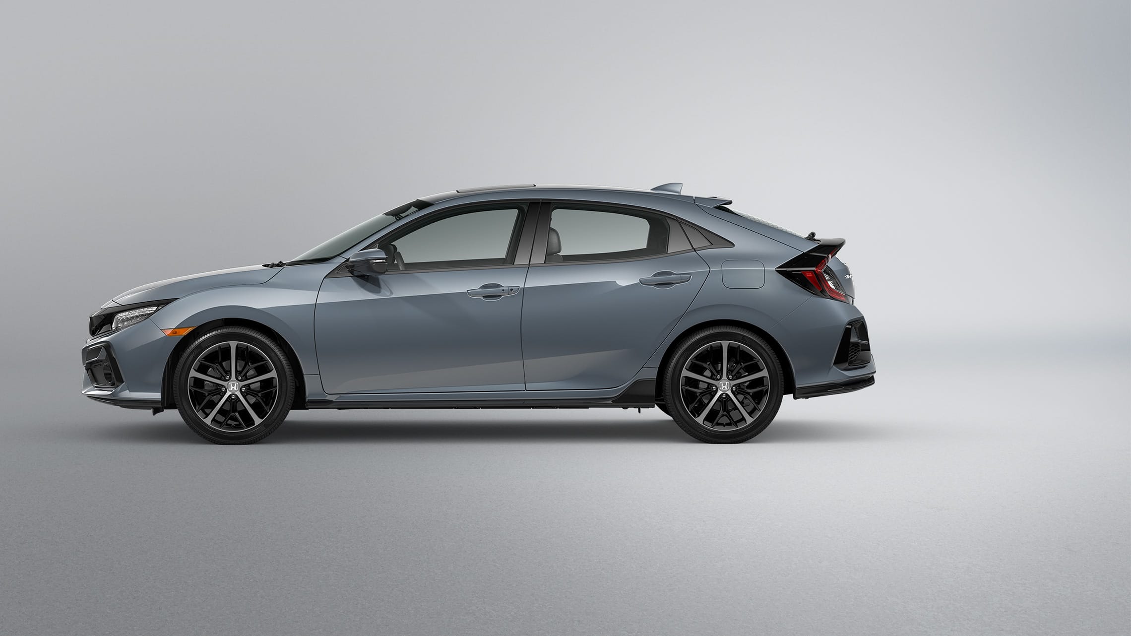 Driver-side profile view of the 2021 Honda Civic Sport Touring Hatchback in Sonic Gray Pearl.