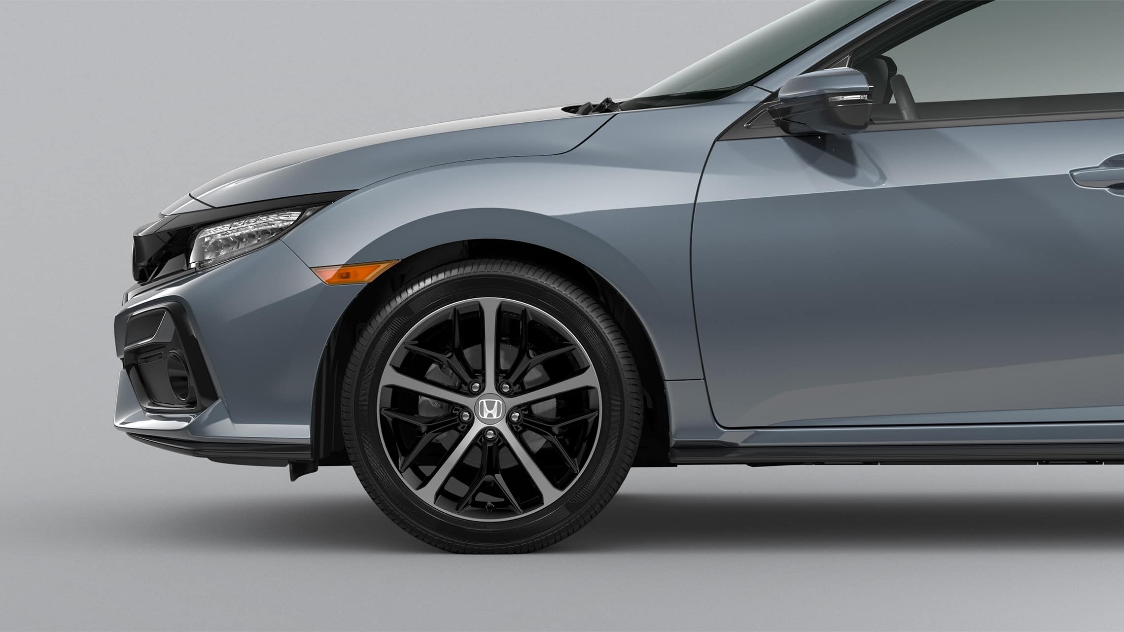 Front passenger-side 18-inch alloy wheel detail on the 2021 Honda Civic Sport Touring Hatchback in Sonic Gray Pearl.
