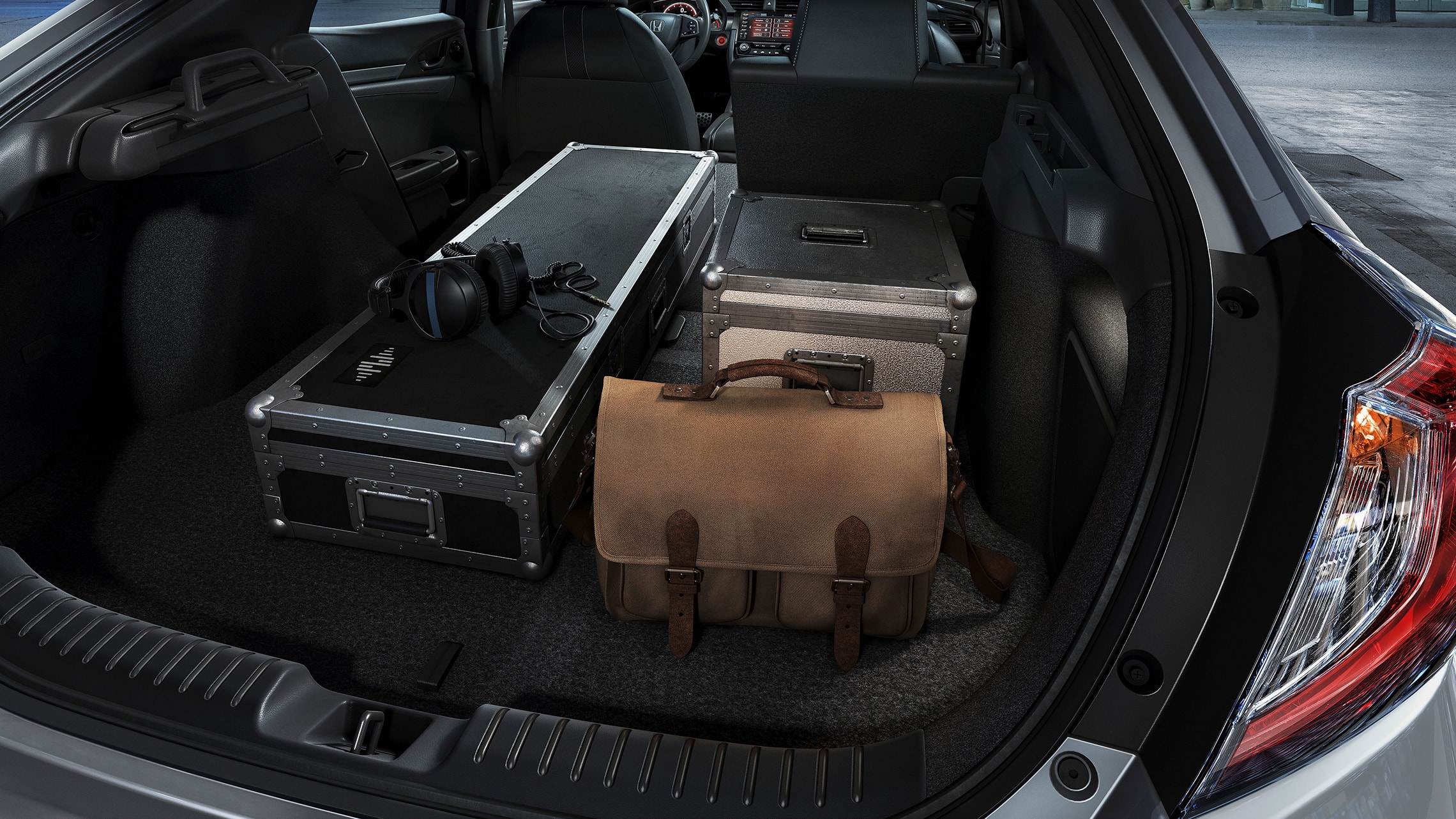Various items loaded into cargo space of the 2021 Honda Civic Sport Touring Hatchback with 60/40 split fold-down rear seatback.