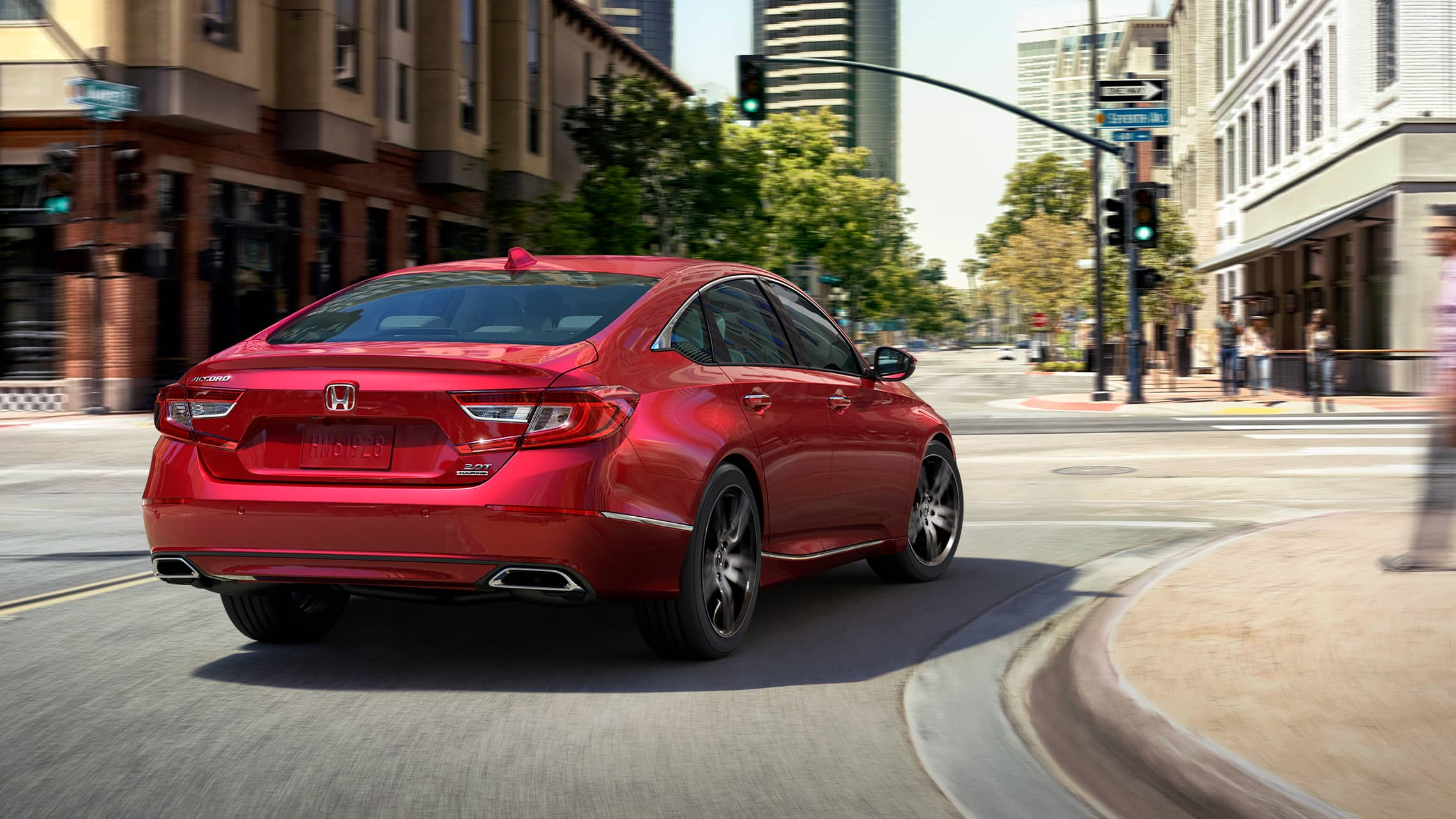 2021 Honda Accord Touring 2.0T in Radiant Red Metallic, making a turn at a downtown intersection.