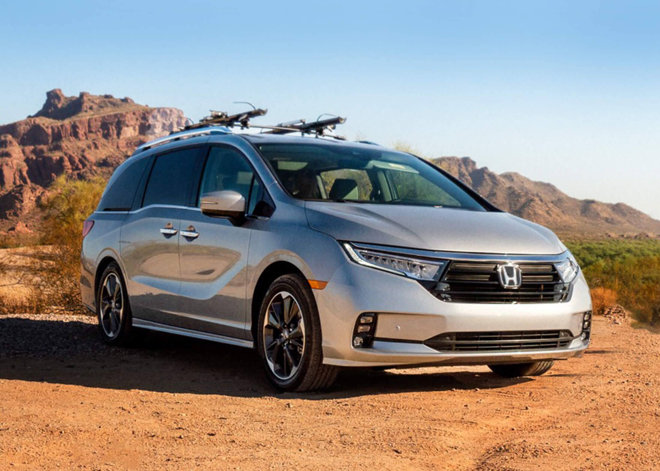 Front passenger-side view of the 2022 Honda Odyssey Elite in Lunar Silver Metallic with Honda Genuine Accessories, parked in the desert.